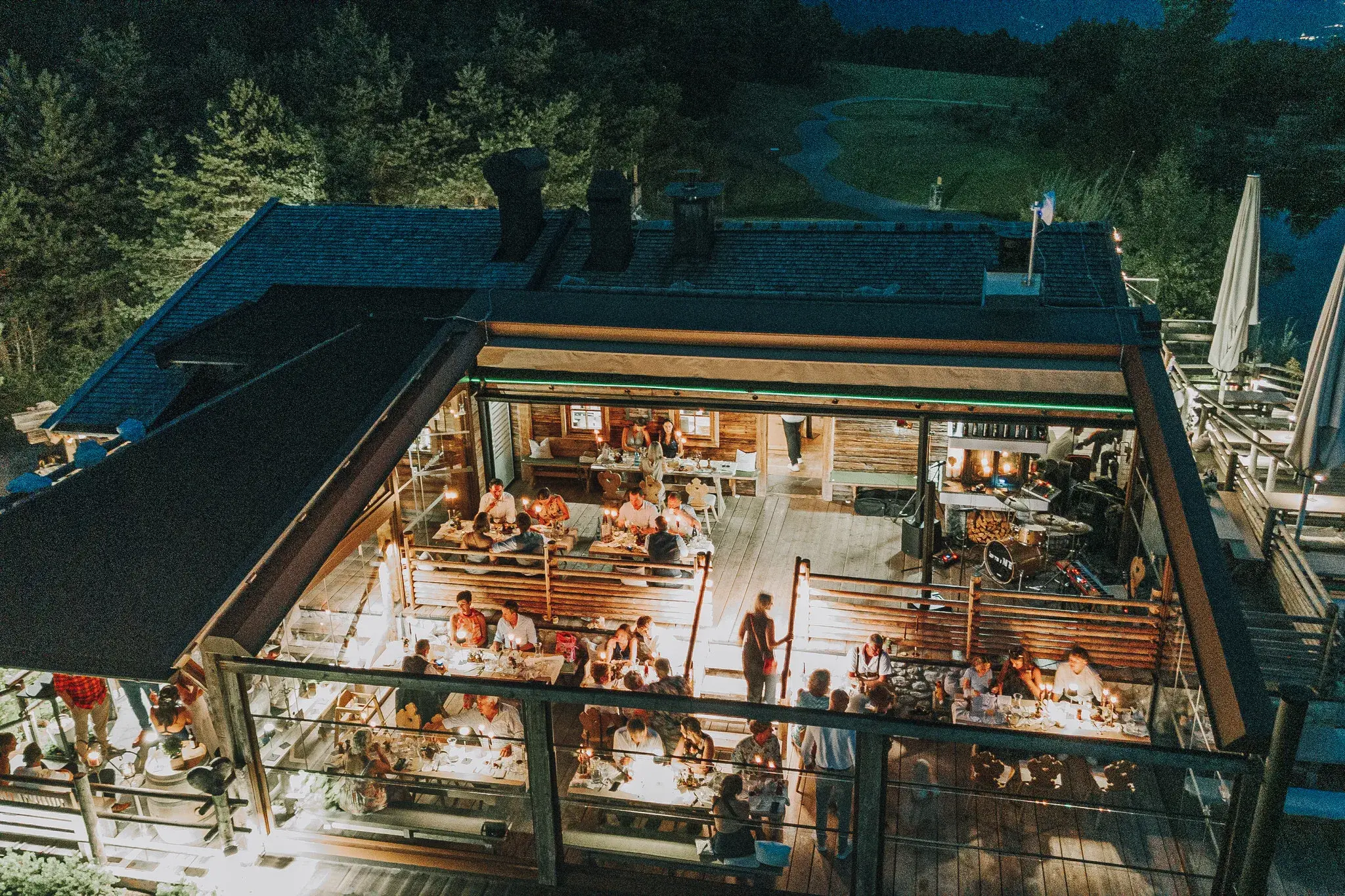 Abendliche Hochzeitsfeier auf der hell beleuchteten Terrasse der Stöttlalm in Mieming bei Dämmerung