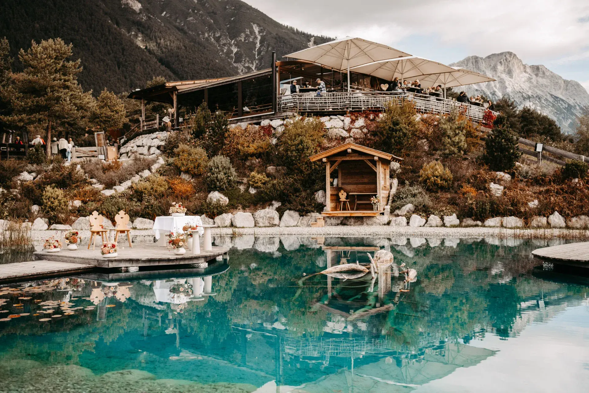 Stöttlalmsee mit Spiegelung der Terrasse vor der felsigen Mieminger Kette und herbstlichen Hängen