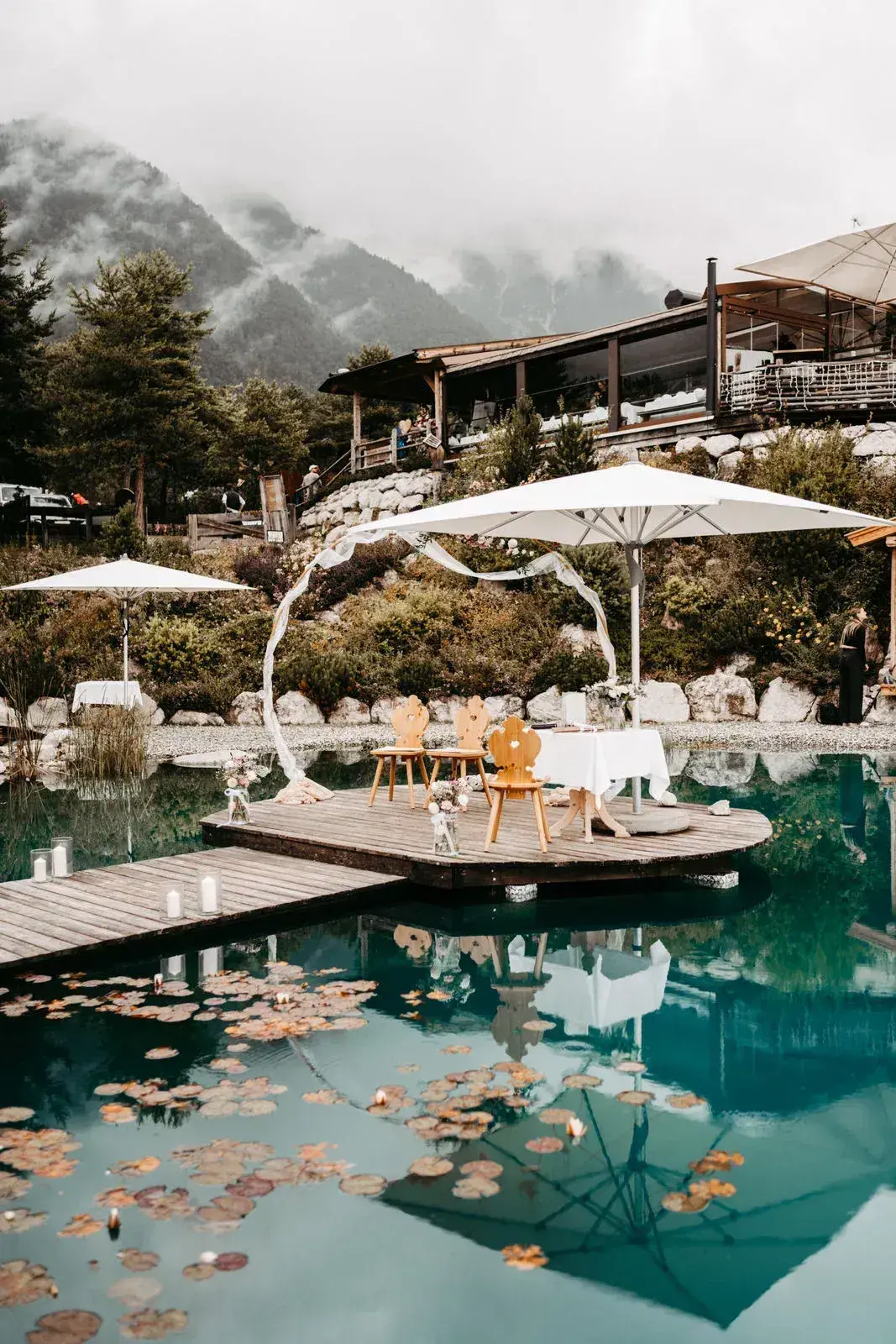 Festlich gedeckte Hochzeitstafel auf dem Holzsteg am Stöttlalmsee, dahinter die Mieminger Kette
