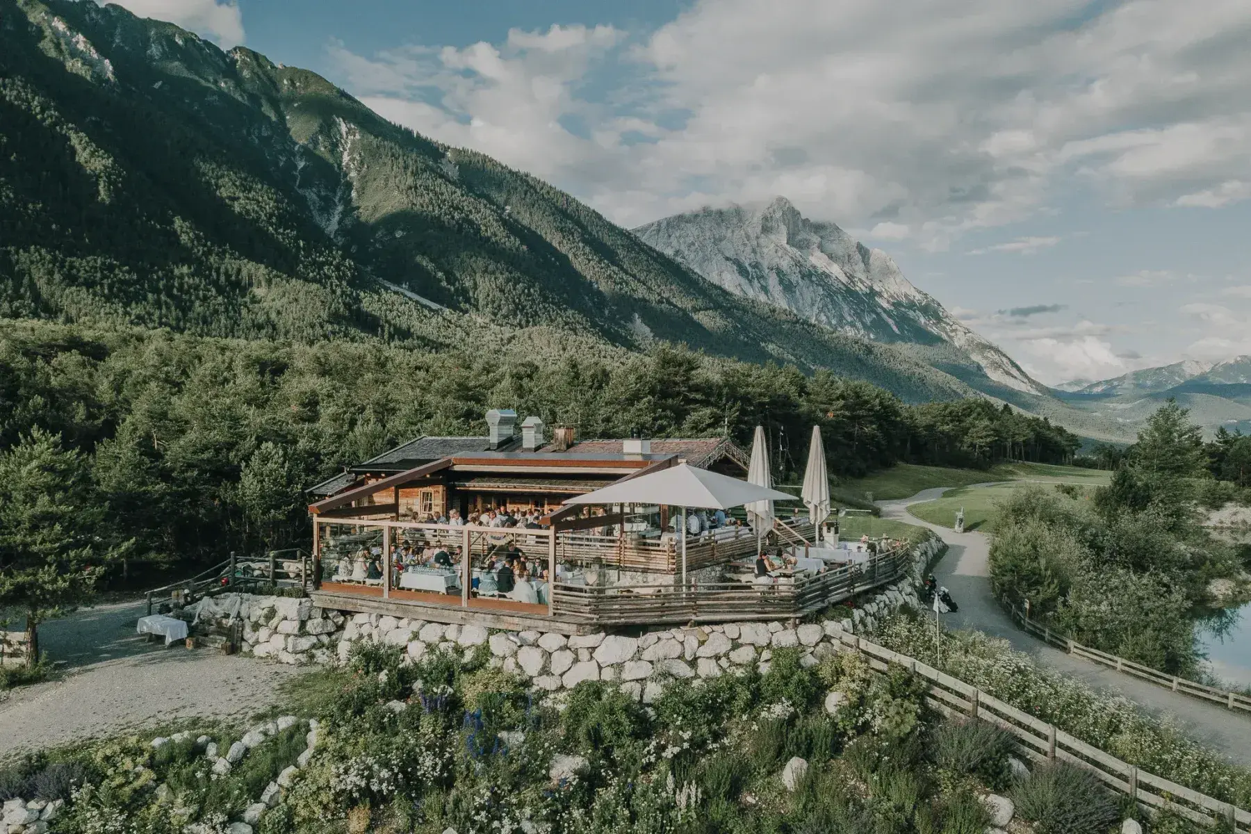 Almhütte Stöttlalm mit überdachter Sonnenterrasse vor der Bergkulisse der Mieminger Kette